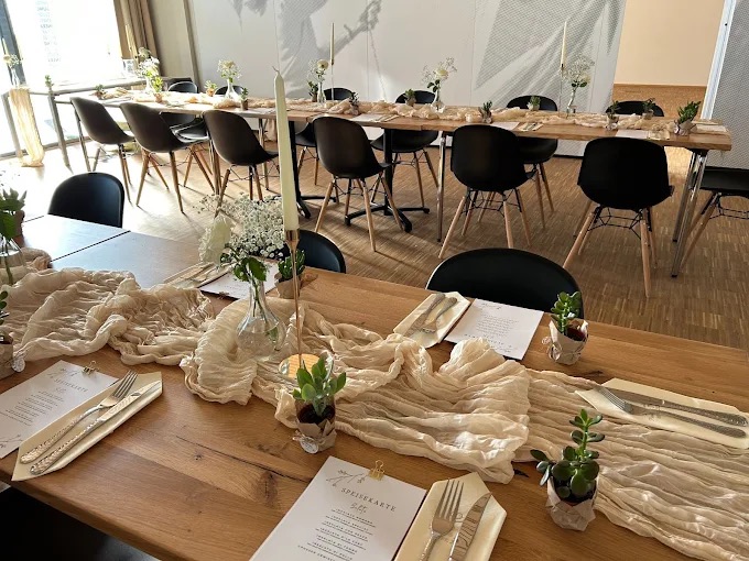 Der separate Raum für Feiern: eine lange gedeckte Tafel unter schlichten Leuchten.