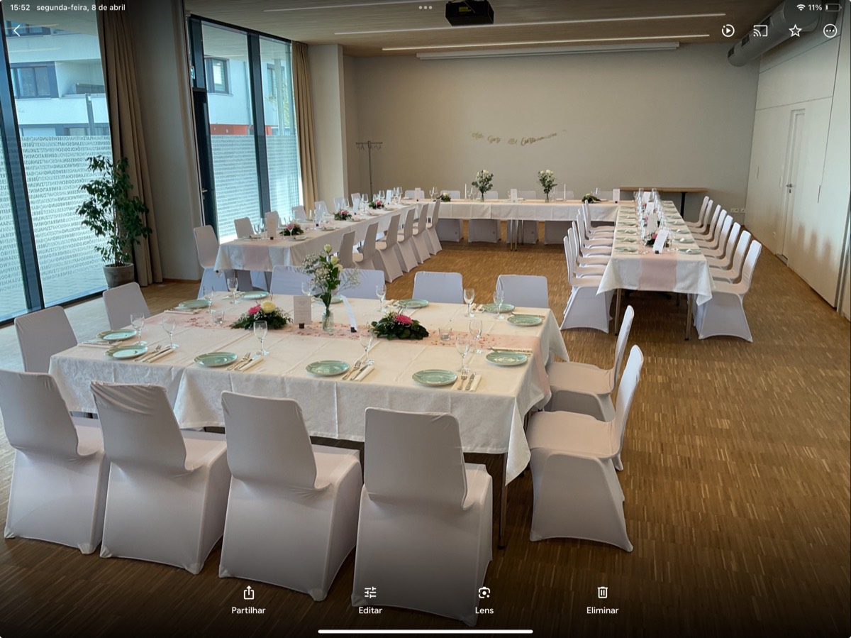 Eine Kommunionsfeier im Q5: eine festlich, aber schlicht eingedeckte lange Tafel im hellen Raum, weiße Blumen und Kerzen.